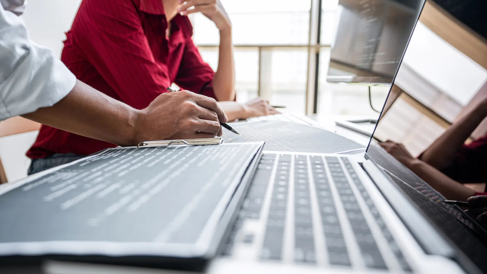 Software development team planning a custom application around a laptop