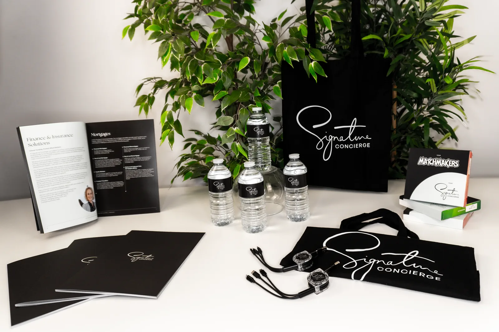 Branded Signature Concierge event merchandise with tote bags, brochures, water bottles and chocolate